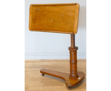 An Edwardian mahogany reading table, circa 1910, the shaped top with adjustable height and tilt mechanism on a turned bulbus 