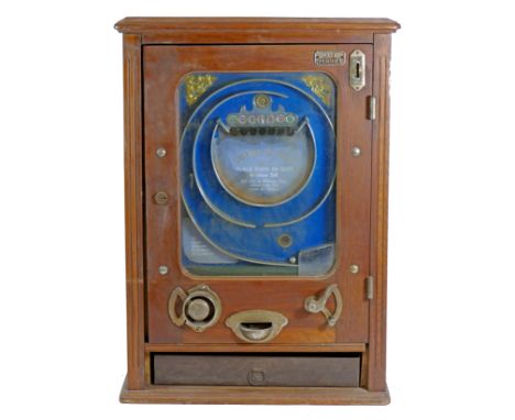 An Allwin De Luxe penny slot machine, c.1920's, oak cabinet, with internal metal ball track, pierced metal decorated and cent