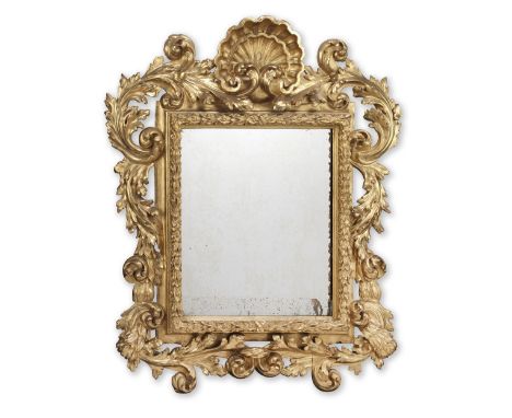 An Italian early 18th century carved giltwood mirrorThe later rectangular plate within a concave slip and projecting entwined