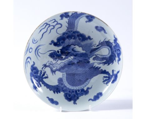 Blue and white porcelain saucer shaped bowl Chinese decorated in the Kangxi style, depicting a five claw dragon surrounded by