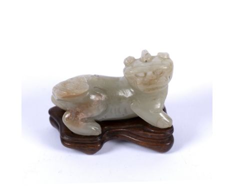 Mutton fat jade carving of a Buddhistic lion Chinese, Ming style standing four square with head looking over its right should