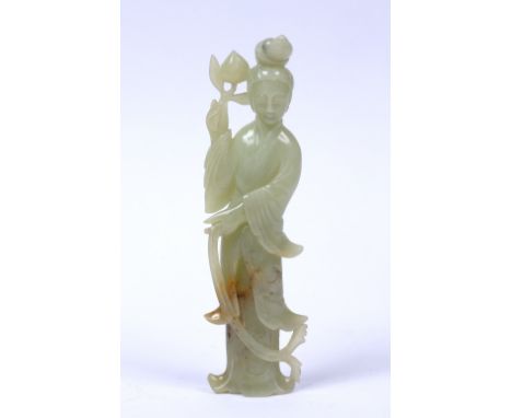 Jade figure of Guanyin Chinese, 19th/early 20th Century the standing figure holding a peach in her right hand, 21cm high