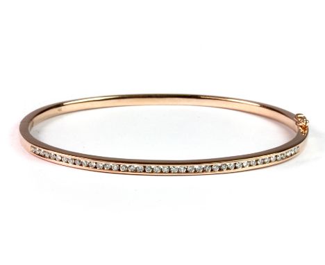 A 9ct rose gold (stamped 9ct) diamond set bangle.