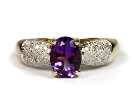 A 9ct yellow gold ring set with an oval cut amethyst and diamond set shoulders (N.5).