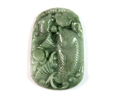 A Chinese carved jadeite jade celedon green amulet of a fish among lotus, L. 5.5.cm.