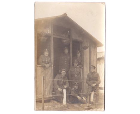 Army Service Corps WWI-RP postcard, group of seven by a very basic hut, clear insignia