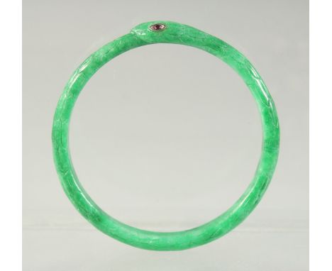 A JADEITE SNAKE-FORM BRACELET with inset ruby eyes, 7cm diameter.