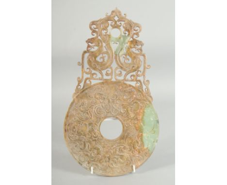 A SUPERB LARGE JADE DISK, with relief and pierced decoration depicting dragons, 34.5cm x 19.5cm.