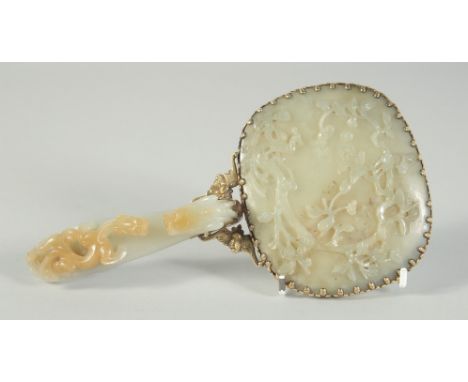 A CHINESE CARVED JADE HAND MIRROR, with metal mounts, the handle made from a carved jade belt hook in the form of a dragon, t