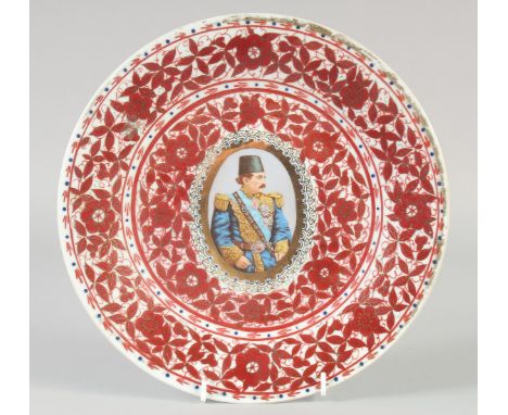 A QAJAR RED AND WHITE PORCELAIN PLATE, with central portrait medallion and foliate decoration, 26.5cm diameter.