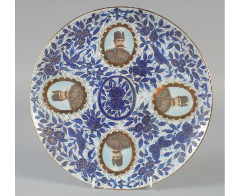A QAJAR BLUE AND WHITE PORCELAIN PLATE, with four portrait medallions and foliate decoration, 26cm diameter.
