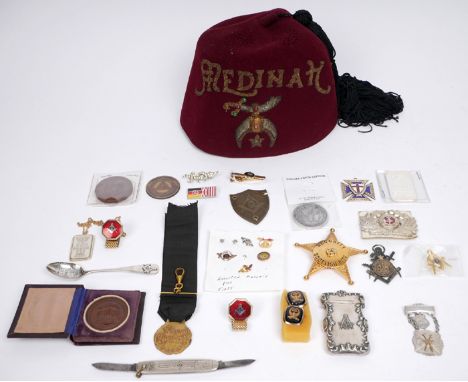 A collection of masonic and fraternal societies' badges and insignia. An American fraternal fez; a white metal vesta with squ