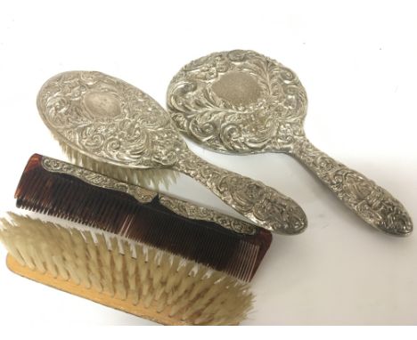 A silver backed dressing table set a hand mirror brushes and comb