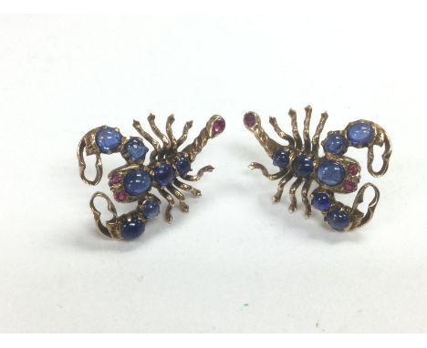 A pair of 9ct gold cabochon, sapphire and ruby earrings in the form of scorpions, approx 6.1g. Shipping category A.
