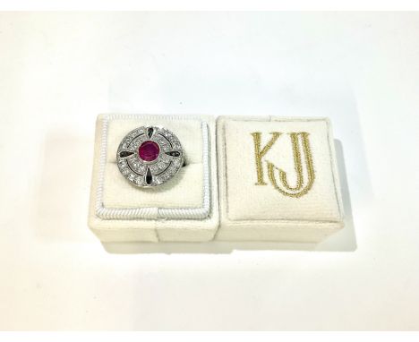 An art deco style cocktail platinum mount ring inset with a ruby and surrounded with round brilliant cut diamonds approx 1.10