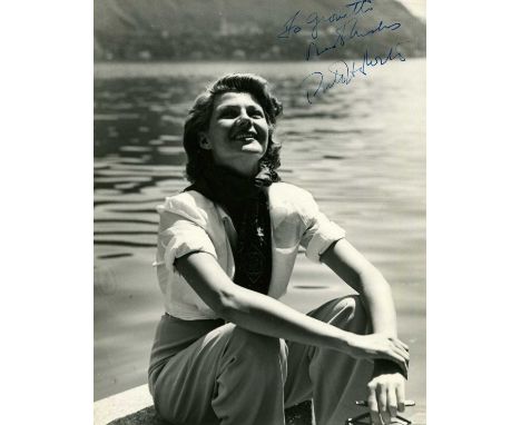 HAYWORTH RITA: (1918-1987) American actress. Vintage signed and inscribed 6.5 x 8.5 photograph of Hayworth seated outdoors in