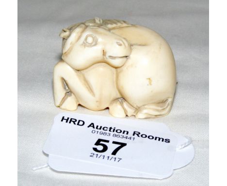 A 19th century carved Japanese netsuke in the form of a resting horse - bearing signature - 4cm