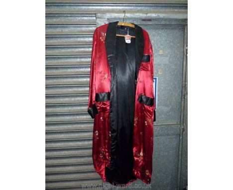 An oriental dressing gown, red ground with black lining and embroidered flowers,slim shawl collar and patch pockets, size 16.
