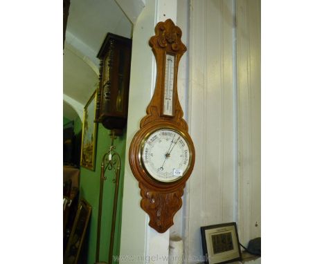A large carved Oak Aneroid Barometer/thermometer, 35" long.