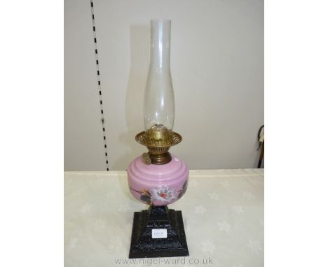 A pink glass with floral design Oil Lamp, standing on a pierced cast square base with twin burner and chimney. 21 1/4" to top