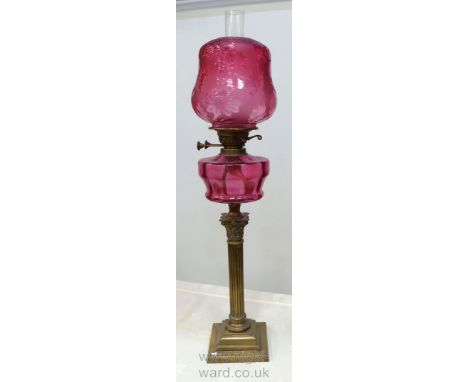 A fine Victorian Oil Lamp having a brass stepped square base, reeded corinthian column, double wick, cranberry glass bombe sh