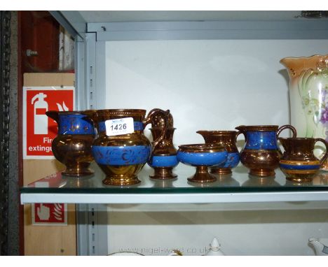 A scarce 19th century Staffordshire copper lustre shaker/sander and a suite of Staffordshire copper lustre jugs.