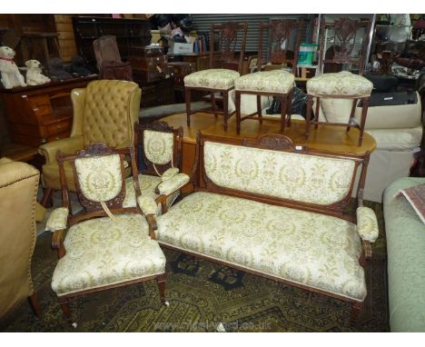 An Edwardian Mahogany/Walnut Salon Suite comprising a two seater open armed Sofa, a pair of matching elbow Chairs, each with 