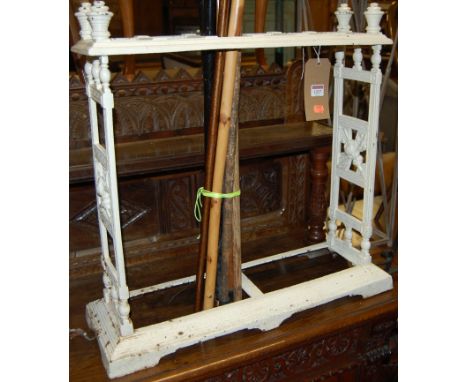 A late Victorian white painted cast iron six division stick stand with sundry contents, width 66cm