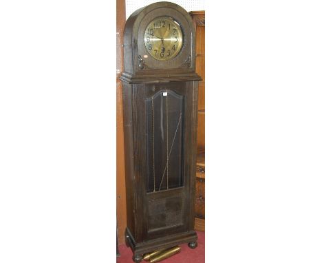 A 1930s moulded oak longcase clock, having a brushed brass dial with twin chain movement, pendulum and two weights