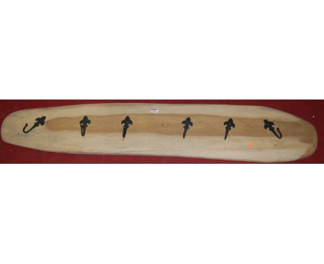 A contemporary light oak and wrought iron wall mounted coat rack, length 140cm