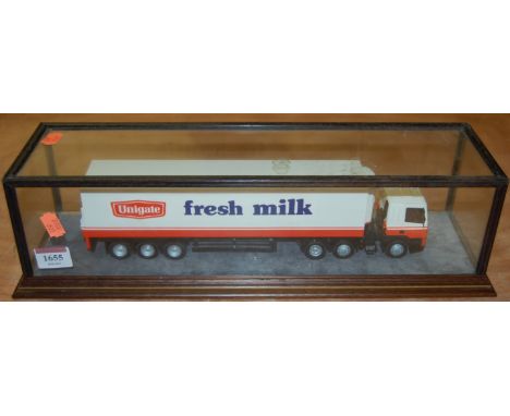 A cased display model of a Unigate fresh milk tractor unit and refrigerator trailer in a glazed and wooden display case