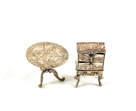 A continental Silver miniature two drawer chest and figure decorated tripod table, unmarked