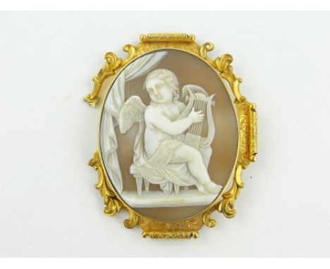 A 19th century carved Cameo brooch,
depicting cherub playing a harp, unmarked engraved scrolled gold frame, height 65mm.