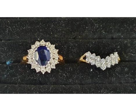 Gold-coloured metal, blue and white stone cluster ring set oval sapphire-coloured stone surrounded by two tiers of small whit