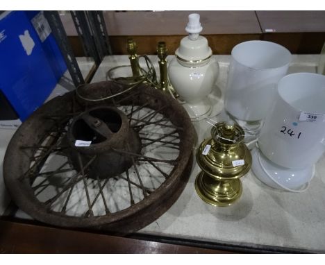 Cast iron vintage cart/car wheel, a pair of brass table lamps, a pair of glass table lamps, a paraffin lamp and another lamp