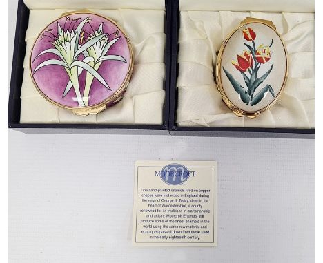 Moorcroft enamel patchbox, circular, purple ground decorated with green flowers, 5.5cm diameter and another, oval, cream grou