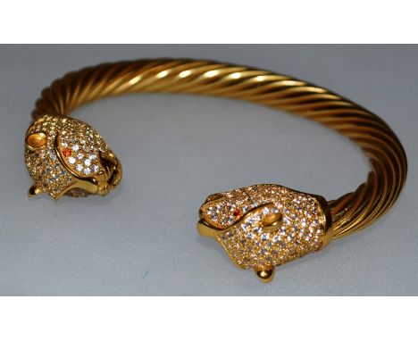 A GOOD SILVER GILT ROPE TWIST BANGLE, with leopard heads to either end, each with crystal and ruby eyes.