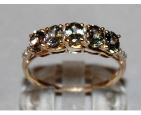 A FIVE STONE RING with zircon shoulders, set in 9ct yellow gold.