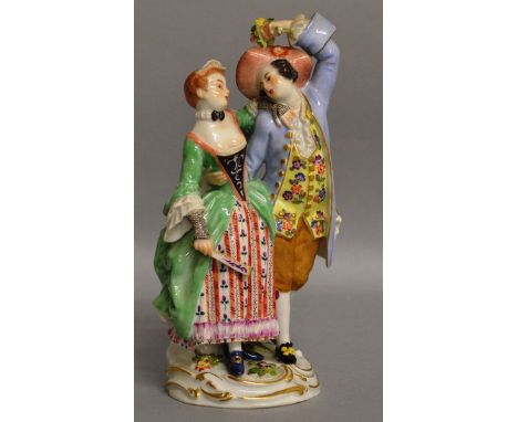 A GOOD SMALL MEISSEN FIGURE GROUP OF YOUNG LOVERS, dressed in colourful garb, the man carrying a bouquet of flowers, the lady