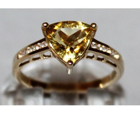 A GOLD AMBER DIAMOND SHAPED STONE RING with zircon shoulders, set in 9ct yellow gold.