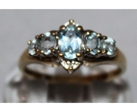 A FIVE STONE RING surrounded by zircons, set in 9ct yellow gold.