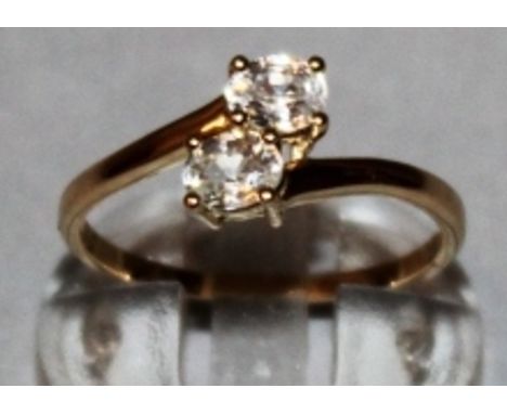 A ZIRCON CROSSOVER RING set in 9ct yellow gold.