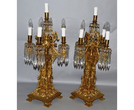 A SUPERB PAIR OF FRENCH BRASS FIVE LIGHT CLASSICAL CANDELABRA, each with four scrolling branches, cut prism drops, mounted wi