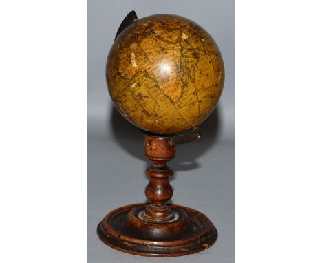 A NEWTONS 7.62cm MINIATURE TERRESTRIAL GLOBE ON A TURNED WOOD STAND, Published by NEWTON & SON.  6ins high.