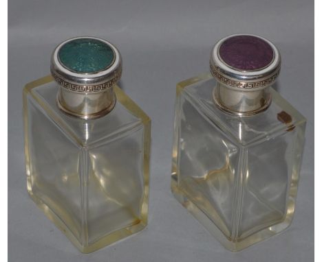 A PAIR OF RECTANGULAR GLASS SCENT BOTTLES with silver and enamel tops.