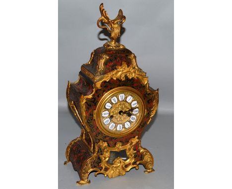A 19TH CENTURY FRENCH BOULLE MANTLE CLOCK with eight day movement, brass inlay on red tortoiseshell, ormolu scrolls. 16ins hi