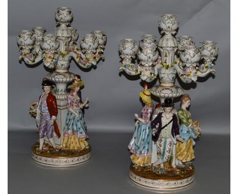 A SUPERB PAIR OF LARGE MEISSEN DESIGN FLOWER ENCRUSTED SEVEN LIGHT CANDELABRA, the bases as four figures, two men and two lad
