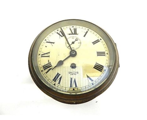 A BRASS SHIP'S BULKHEAD CLOCK, BY SMITHS (EMPIRE) with a black Roman numeral chapter ring against a white dial, diameter 18cm