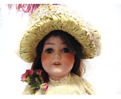 A CHARLES BERGMANN BISQUE SOCKET-HEAD DOLL with a (replacement) long brown wig, sleeping blue-grey eyes, and an open mouth wi