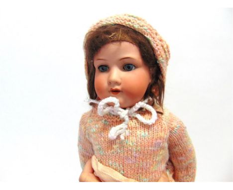 AN ARMAND MARSEILLE BISQUE SOCKET-HEAD DOLL with a brown wig, sleeping blue glass eyes, and an open mouth with four upper tee